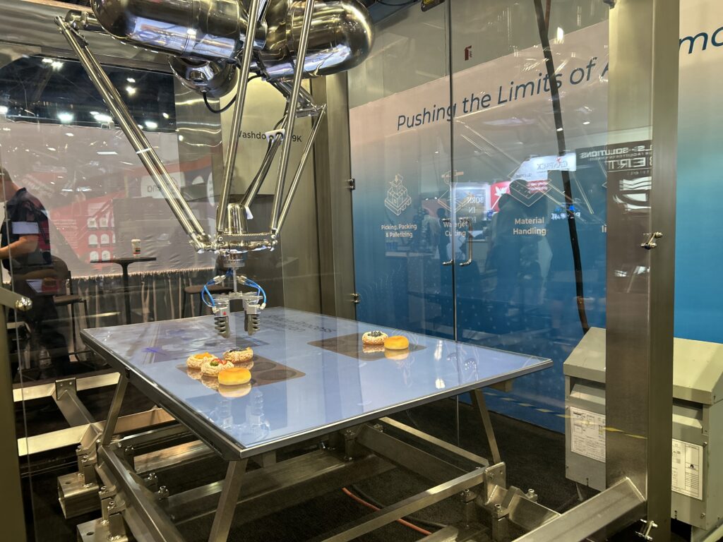 Shape Process Automation highlighted its FlexPicker, a hygienic delta pick-and-place robot designed for high speed handling. The system was demonstrated at Pack Expo Las Vegas moving around donuts and pastries.
