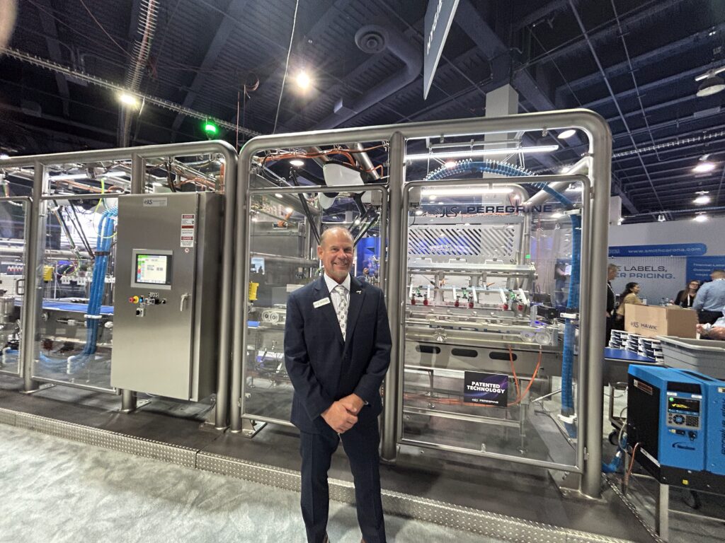 Gary Pickett, senior director of secondary packaging for JLS Automation, poses next to the Peregrine robotic cartoner at Pack Expo 2025 at the Las Vegas Convention Center. The system features vision-guided robotics and a compact footprint. Source: Sarah Wynn