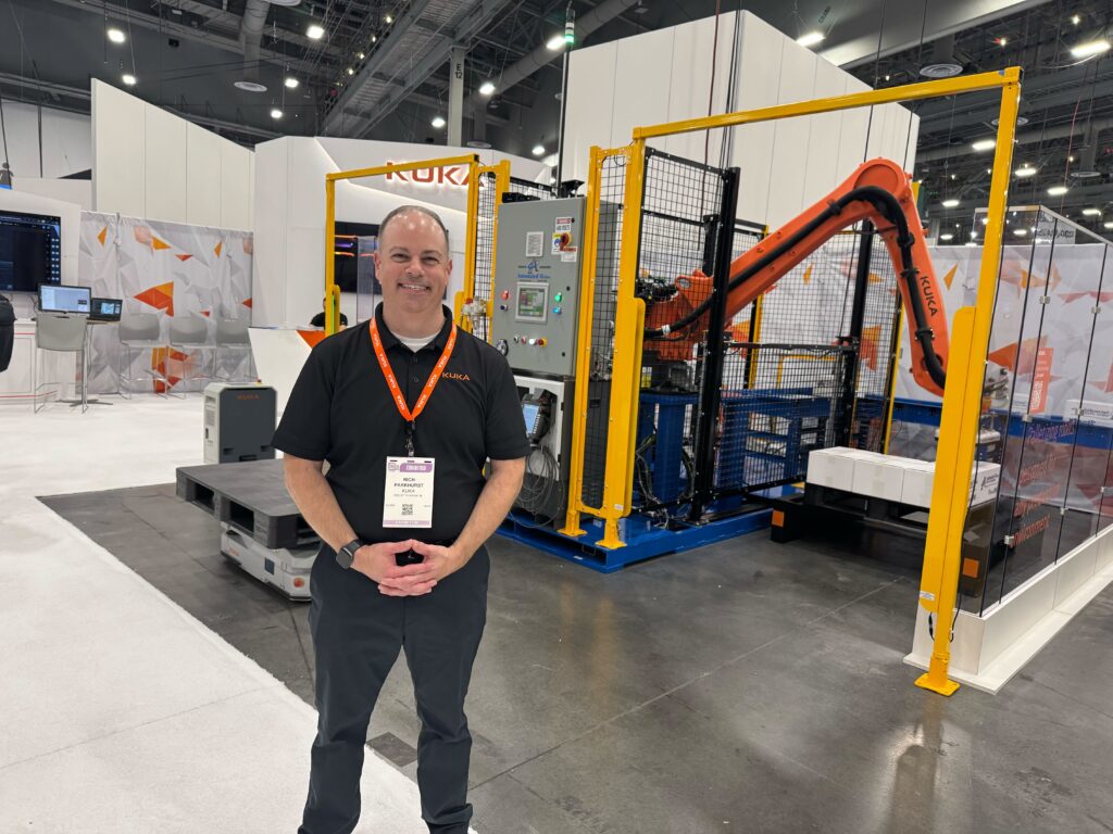 Rich Parkhurst, business development manager at Kuka, poses in front of the VersaPal-KR end-of-line palletizer featuring the Kuka KR180 robot and KMP 600P pallet handling system at Pack Expo 2025 at the Las Vegas Convention Center.