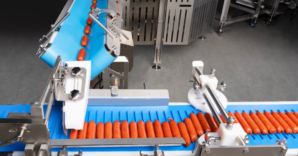 JLS Automation’s Kestrel high-speed robotic collate-and-load system singulates and loads uniform protein products, including sausages, into primary packaging with continuous rotary acceleration for hygienic, high-throughput food packaging