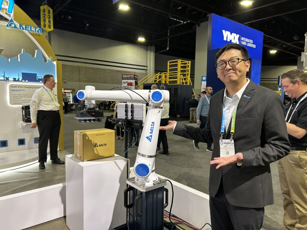 Daniel Chen, Product Manager for Delta Electronics Americas, at the company’s booth during Modex 2026 in Atlanta, Georgia, standing next to a collaborative robot (cobot).