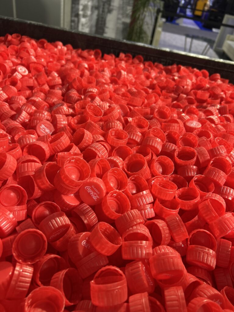 ORBIS Corporation showcased reusable packaging at Modex 2026 in Atlanta, Georgia, featuring Coca-Cola bottle caps in a large reusable tote designed to support automated material handling.