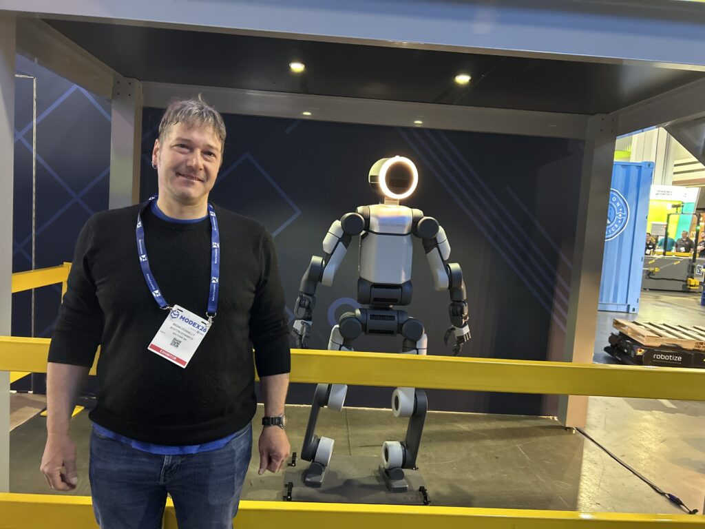 Brian Donnelly, VP & GM of Warehouse Robotics at Boston Dynamics, standing next to the Atlas humanoid robot at Modex 2026 in Atlanta, Georgia.