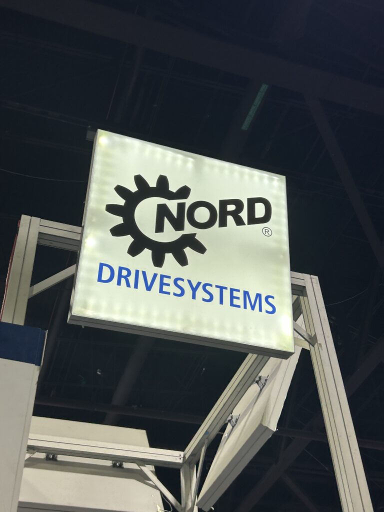 A view looking up at the Nord Drivesystems logo illuminated above the booth at Modex 2026 in Atlanta, Georgia.