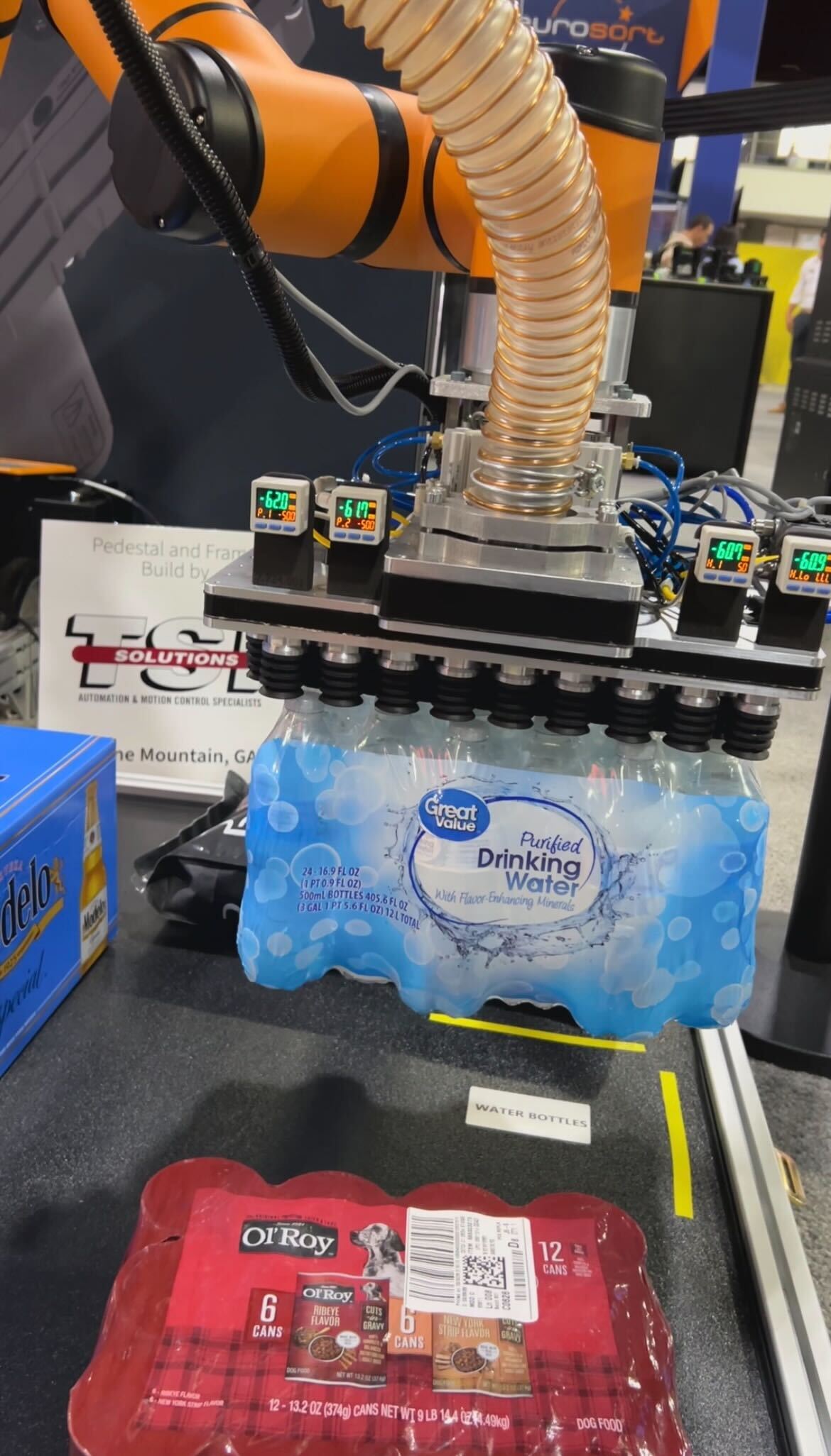 Piab Group BLFF vacuum suction cup demonstrated with an AUBO Robotics USA system at Modex 2026 in Atlanta, Georgia, showing handling of water containers and other items including flexible bags, cases of water, and packages with cans.