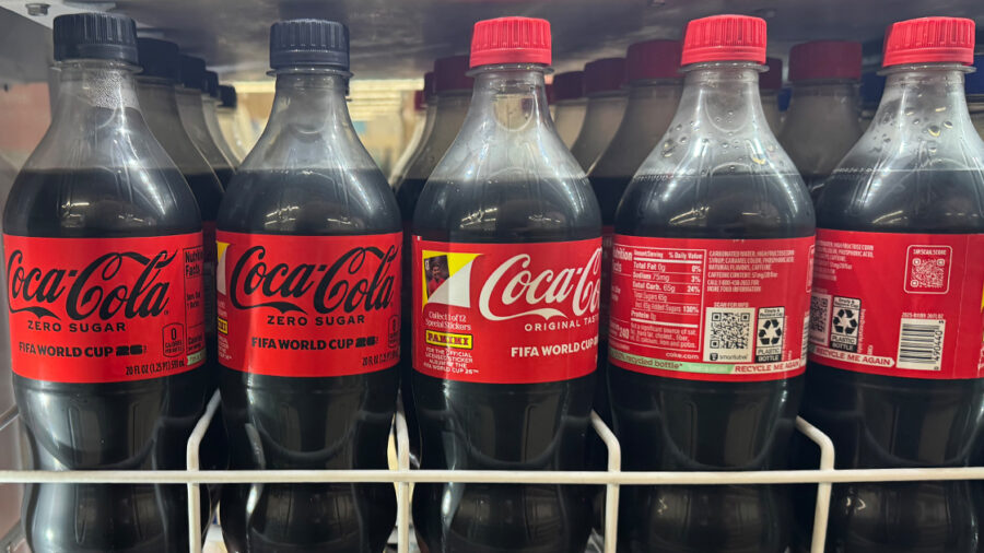 Coca-Cola and Coca-Cola Zero Sugar bottles with peel-off collectible stickers are displayed on an Ohio retail shelf as part of the company’s FIFA World Cup packaging campaign.
