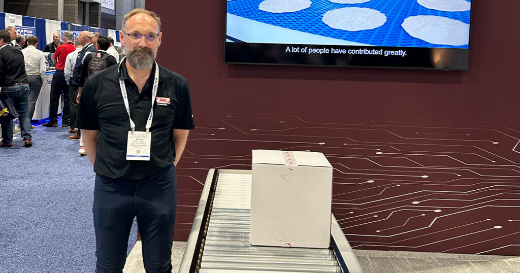 Xavier Le Gros, general manager at AMC Automation, stands with the company's Zero-Pressure Accumulation (ZPA) Conveyor System at Automate 2026 in Chicago.