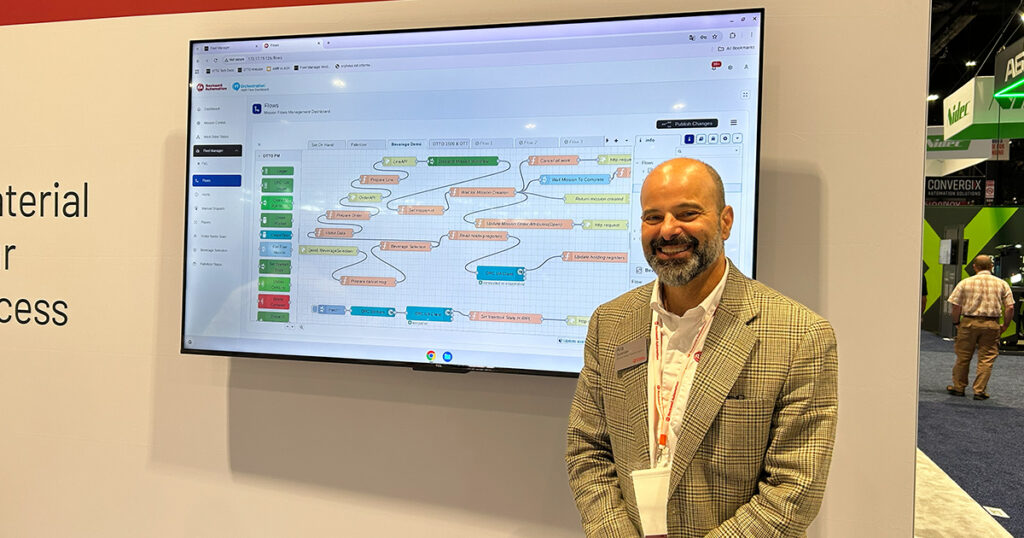 Ara Surenian, business manager for production logistics at Rockwell Automation, stands beside the FactoryTalk Orchestration display at Automate 2026 in Chicago.
