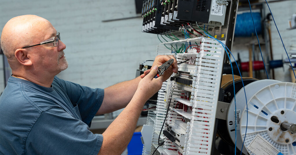 A Triangle Package Machinery employee assembles electrical controls at the company’s Chicago manufacturing facility.