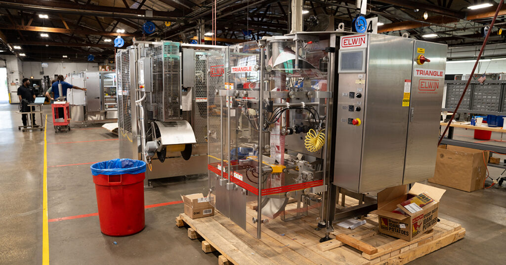 An ELWIN intermittent-motion vertical form-fill-seal (VFFS) machine is assembled on the shop floor at Triangle Package Machinery’s Chicago facility.