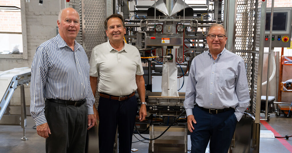 Triangle Package Machinery CEO Bryan L. Muskat, vice president of business development Paul Muskat, and vice president of manufacturing, safety and environmental services David Muskat stand on the shop floor at the company’s Chicago manufacturing facility.