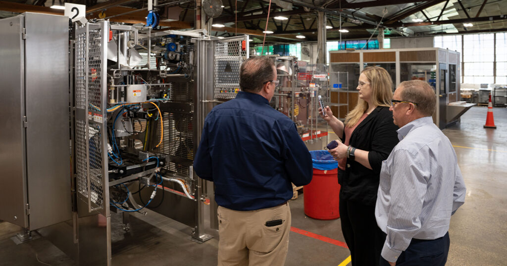 John Cooke, director of sales, and Bryan Muskat, CEO of Triangle Package Machinery, show Packaging OEM senior editor Sarah Wynn around the company’s Chicago shop floor.